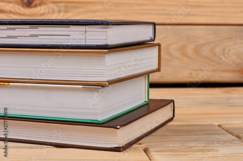 Four books on wooden background. Stack of books. Education and information concept.