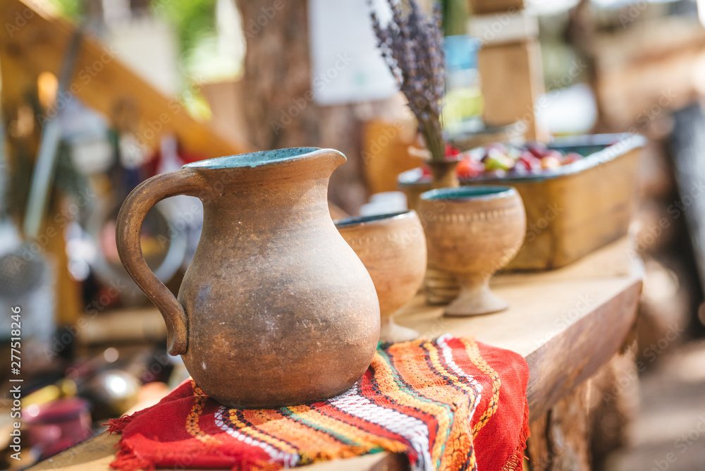 Handmade clay pottery on a wooden shelf. Art festival decoration Handmade clay pottery on a wooden shelf. Art festival decoration