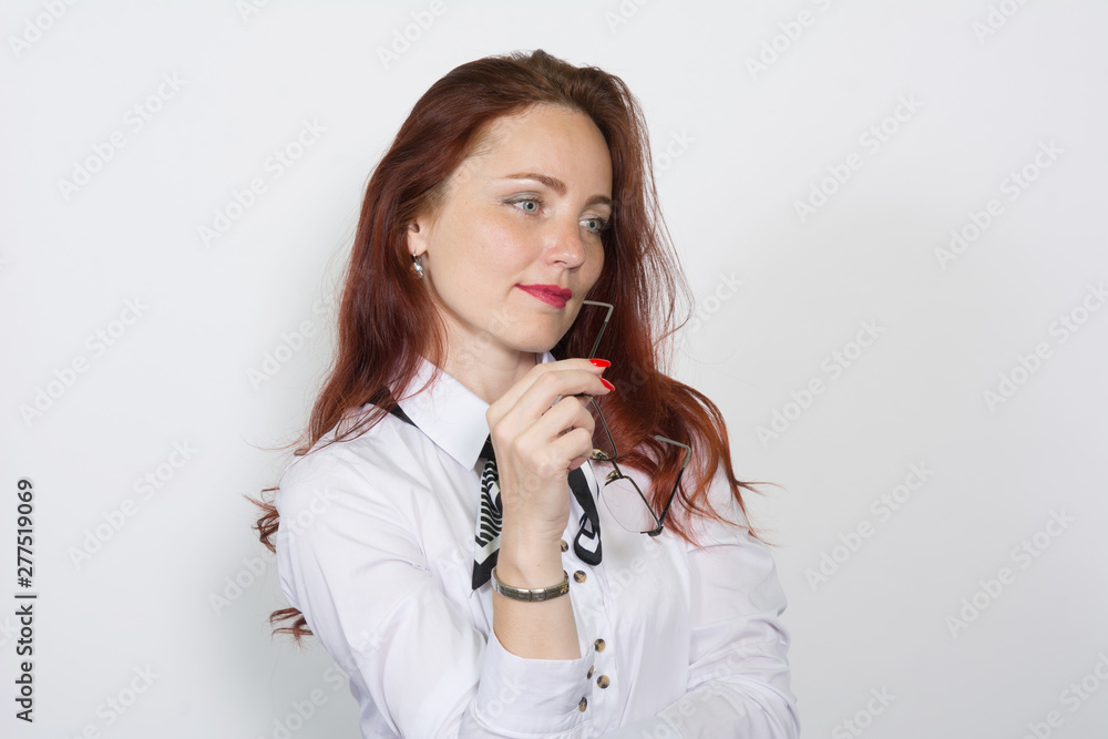 Closeup portrait of red-haired woman with glasses in her hand thoughtfully looking side isolated Closeup portrait of red-haired woman with glasses in her hand thoughtfully looking side isolated