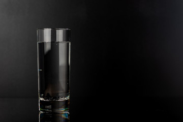 Glass of water on black background