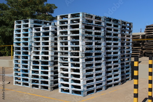 Used wooden pallets stocked at an industrial yard, ready for sale