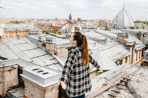 A girl on the roof of a house in solitude meditates or enjoys life or a digital detox. The search for the soul.