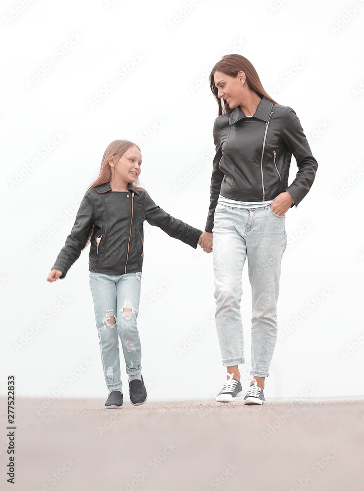 portrait of a mother and daughter walking together portrait of a mother and daughter walking together