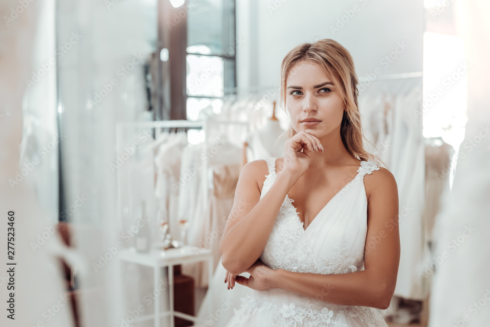 Young woman in a wedding dress looking thoughtful. Young woman in a wedding dress looking thoughtful.