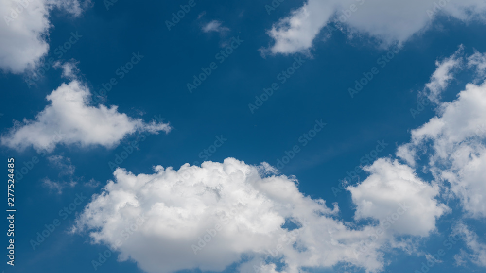 Panoramic view of a bright blue sky with fluffy white clouds on a sunny day Panoramic view of a bright blue sky with fluffy white clouds on a sunny day