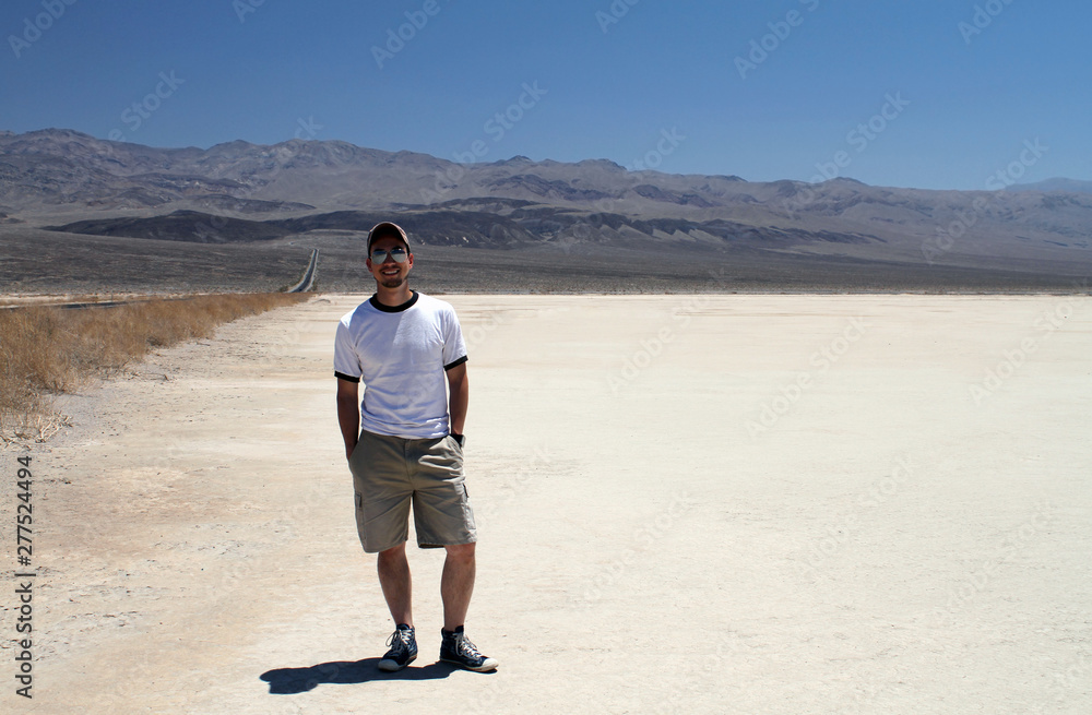 Young man with shorts and sunglasses posing in the desert of Death Valley, California Young man with shorts and sunglasses posing in the desert of Death Valley, California