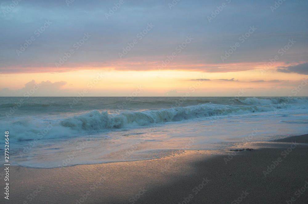 Fototapeta premium Sunset sky over the sea, waves and beach