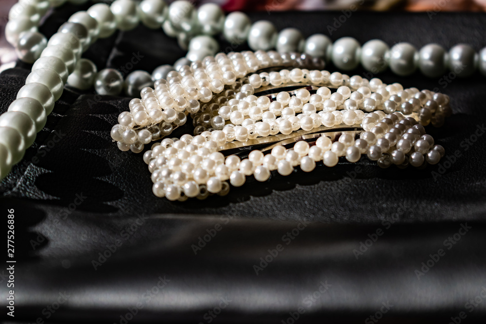 Beautiful and fashionable decoration of white beads of pearls, a nice milky color, on a black leather background. Hair accessories, round and large.