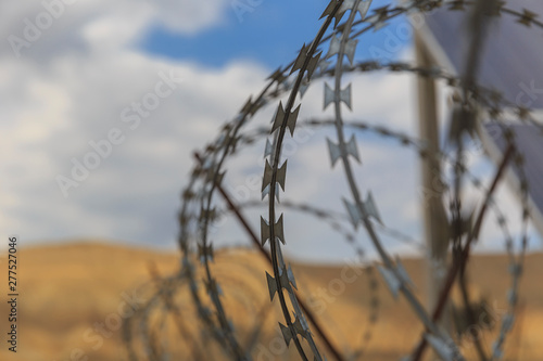 Barbed wire drawn in circles against a background of mountains