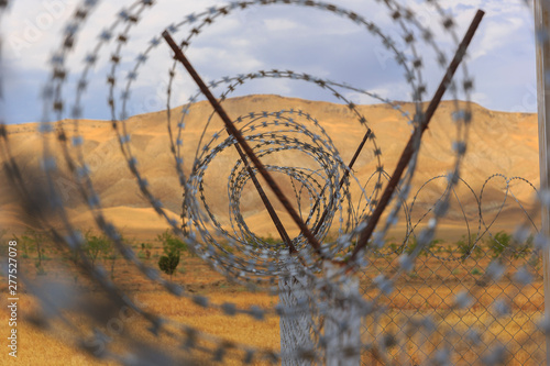 Barbed wire drawn in circles against a background of mountains