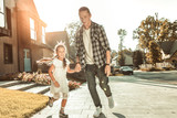 Stylish young father in checkered shirt and jeans playing with little girl