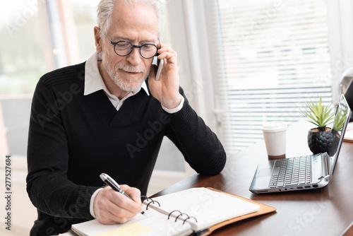 Businessman talking on mobile phone to make an appointment photo