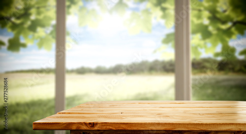 Wooden desk of free space and summer window background 