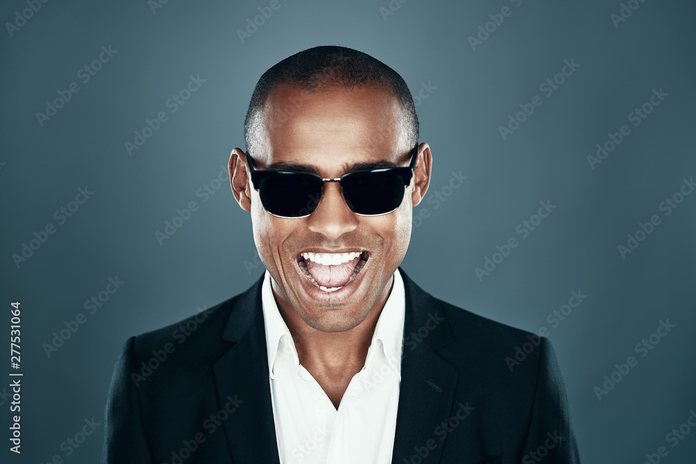 So handsome! Charming young African man in full suit looking at camera and smiling while standing against grey background So handsome! Charming young African man in full suit looking at camera and smiling while standing against grey background