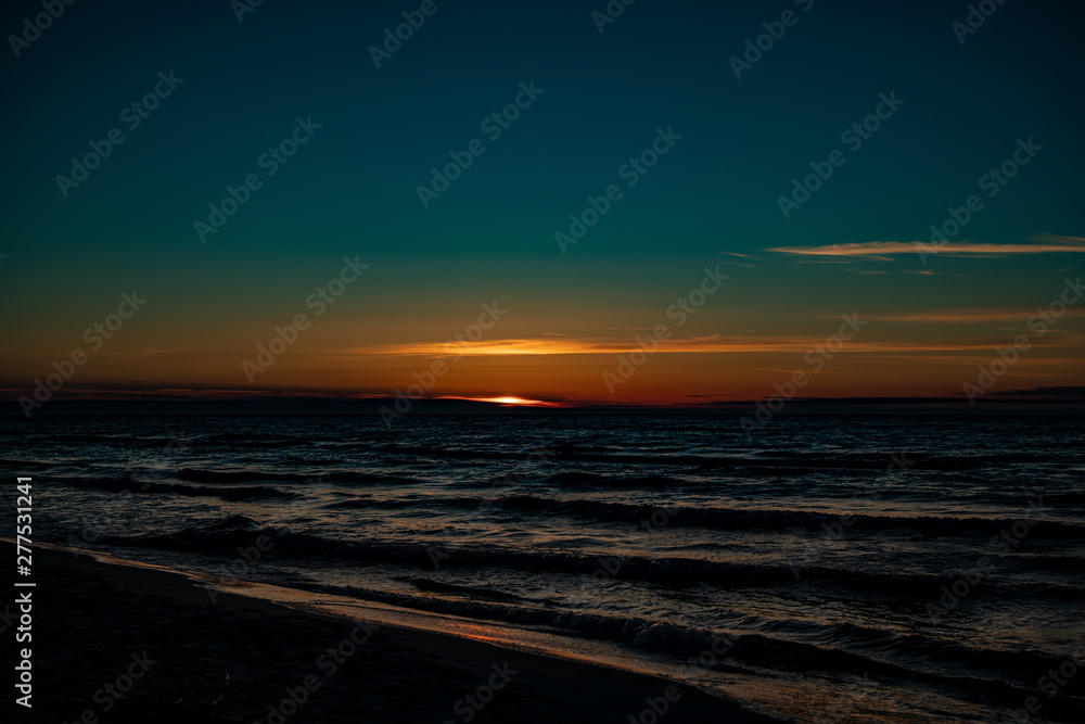  picturesque calm sunset with colorful clouds on the shores of the Baltic Sea in Poland