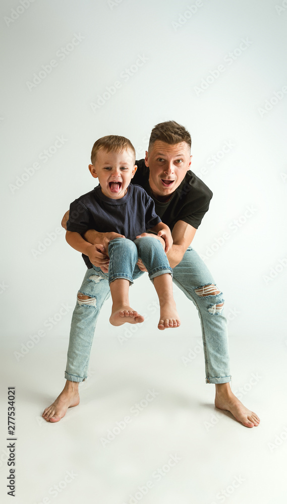 Happy father holding adorable little son and smiling at camera. Young parent with child playing and laughting. Family lifestyle. Father's day, togetherness, parenthood and kid's rights concept. Happy father holding adorable little son and smiling at camera. Young parent with child playing and laughting. Family lifestyle. Father's day, togetherness, parenthood and kid's rights concept.