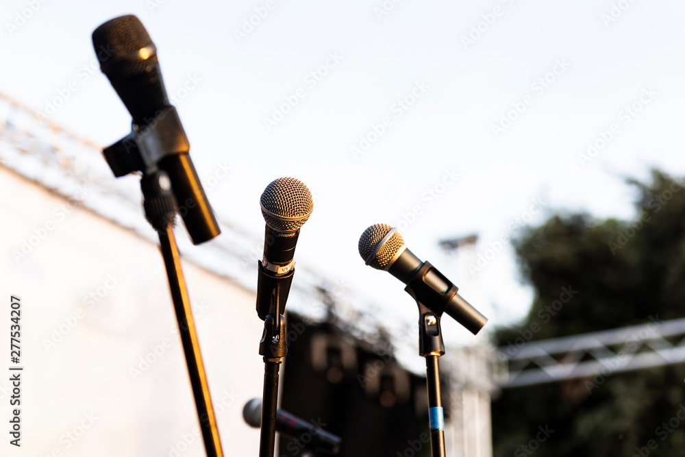 Obraz premium several microphones before a concert, in the background the sky