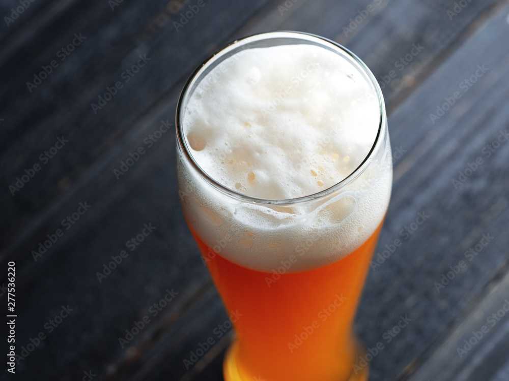Close-up of a glass of wheat beer on a dark wooden background Close-up of a glass of wheat beer on a dark wooden background