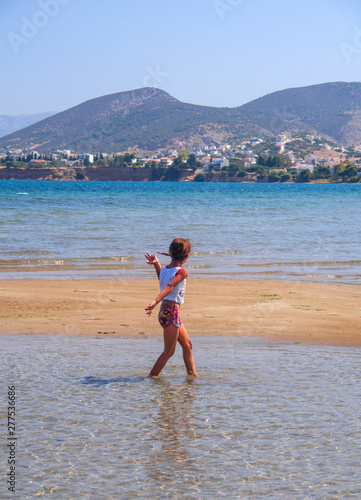 Gypsy Girl running on the sand of Liani Ammos beach on a Sunny summer day. Chalkida, Evia Island photo