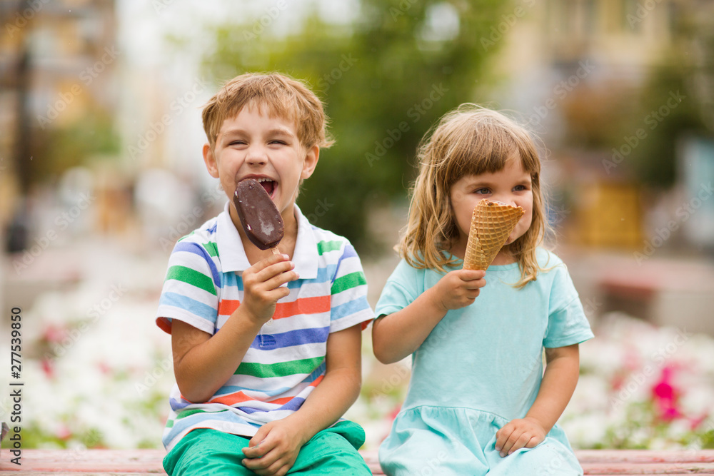 Fototapeta premium Cute happy kids eating icecream outdoors. childhood concept.