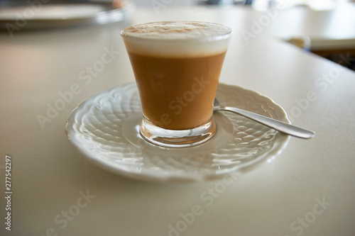 Spanish Cortado (cut) or Italian Macchiato. Traditional coffee espresso mixed with hot foamed milk. Small transparent cup. Morning drink. Cafeteria, restaurant vacation holidays relaxation wake-up. photo