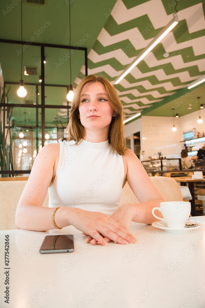 Girl is waiting for a meeting in cafe Girl is waiting for a meeting in cafe