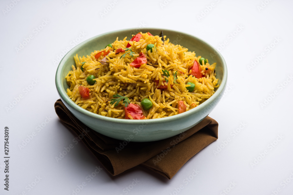 Tomato Rice also known as Tamatar Pilaf/pulav made using basmati rice, served in a bowl. selective focus Tomato Rice also known as Tamatar Pilaf/pulav made using basmati rice, served in a bowl. selective focus