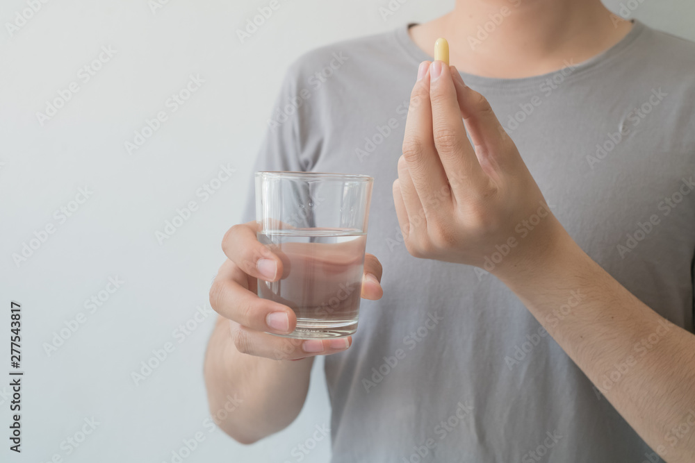 Men hold medicine and water in their hands. Medical and health concepts Men hold medicine and water in their hands. Medical and health concepts
