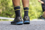 Man runner feet on road in Park workout wellness soft focus and focus close up on shoe