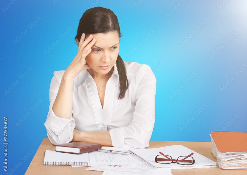 Businesswoman sitting at the table with many papers in office Businesswoman sitting at the table with many papers in office