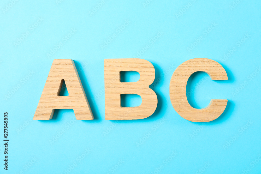Wooden letters of English alphabet on color background, space for text Wooden letters of English alphabet on color background, space for text