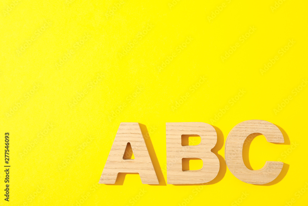 Wooden letters of English alphabet on color background, space for text Wooden letters of English alphabet on color background, space for text