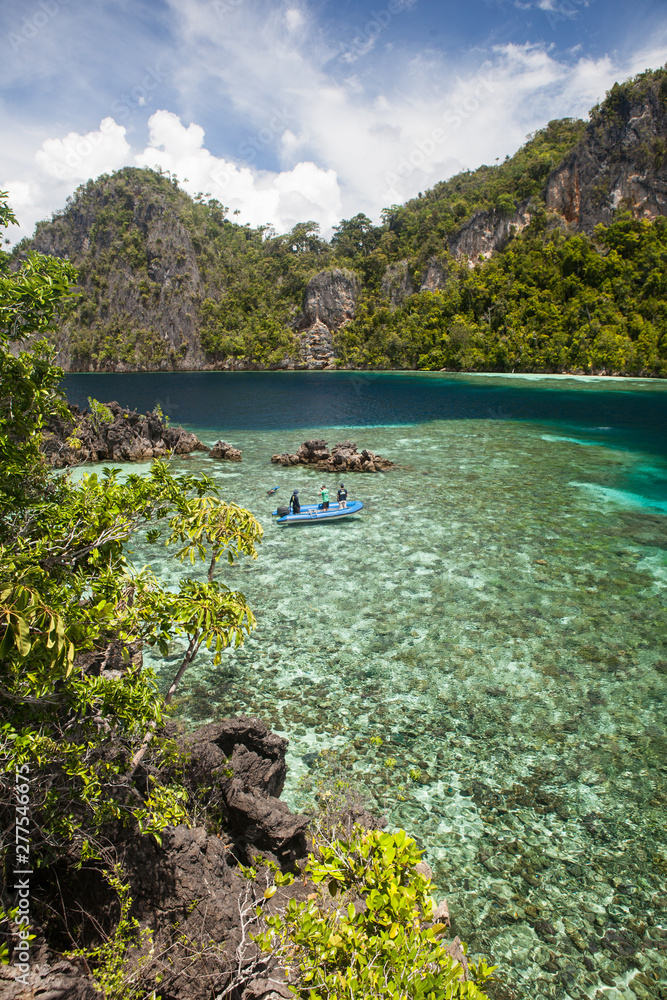 A shallow reef flat fringes the rugged limestone islands of Raja Ampat, Indonesia. This tropical region, part of the Coral Triangle, is known for its incredible marine biodiversity.