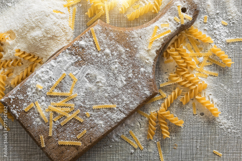 Flour and macaroni on a wooden and rustic table. photo