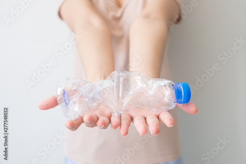 Two hands twisting clear plastic bottle on isolated white background and including clipping path, Resize plastic bottle before recycle, Global warming solution