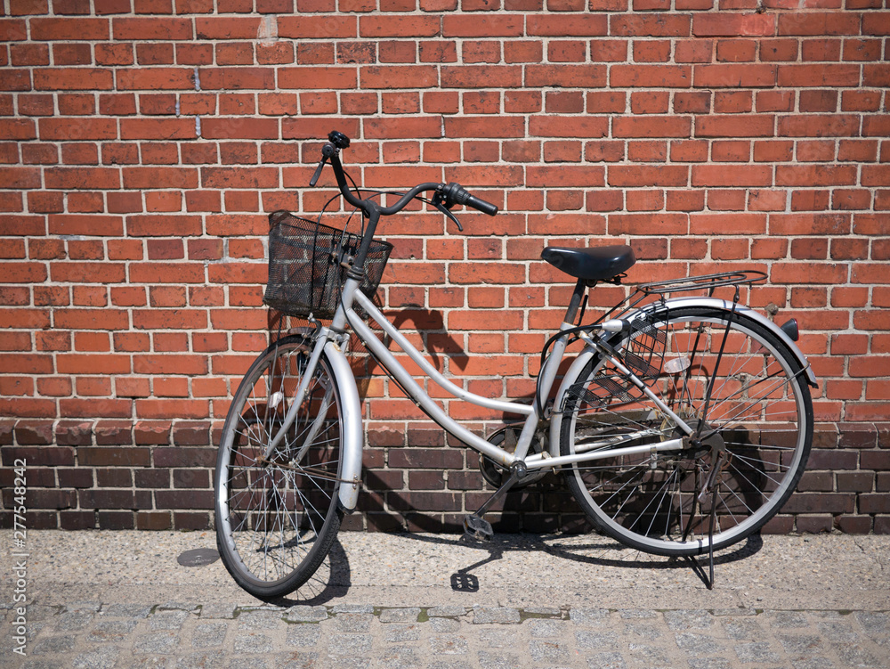 Bicycle on Roadside with Brick Wall Background