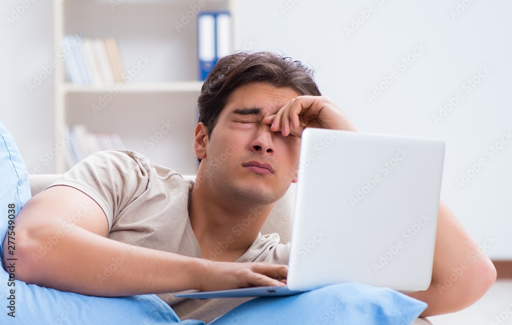 Man working late at his laptop at home Man working late at his laptop at home