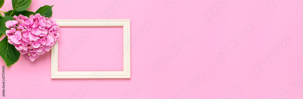 Beautiful pink hydrangea flowers, white wooden photo frames on pink background top view flat lay copy space. Flower card. Holiday, congratulations, happy mothers day. International Women's day