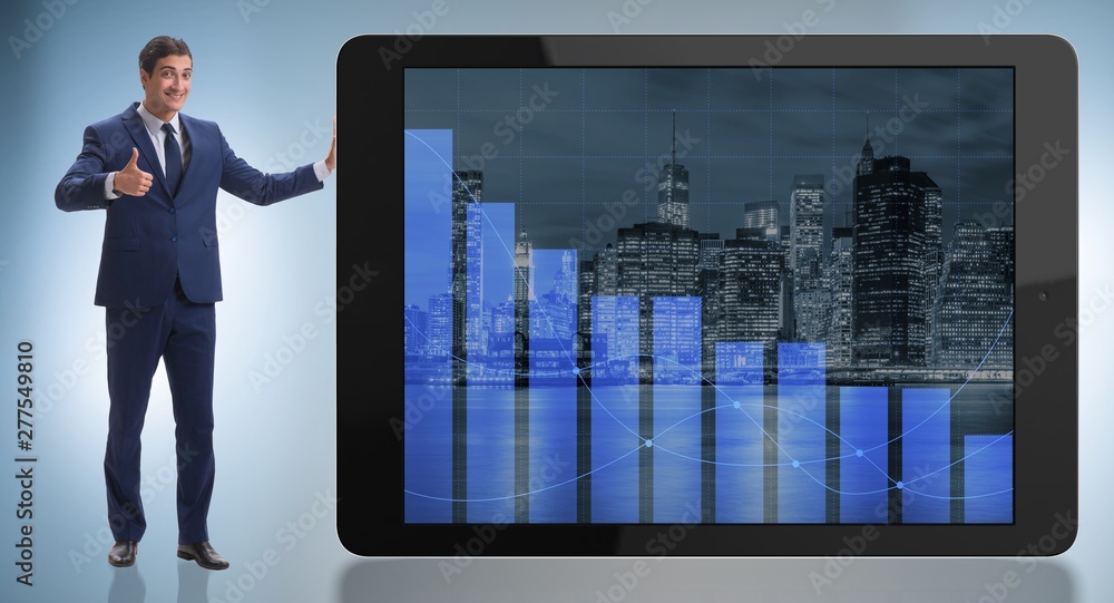 Fototapeta premium Businessman standing next to tablet computer in business concept