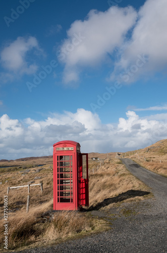 Red phone booth in Scottish countryside.