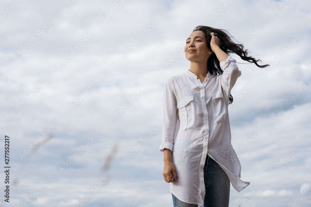 Portrait of cheerful asian woman walking in field, breathing fresh air. Happy Korean girl looking for inspiration, enjoying beautiful landscapes, windy weather and relaxing outdoor. Positive lifestyle Portrait of cheerful asian woman walking in field, breathing fresh air. Happy Korean girl looking for inspiration, enjoying beautiful landscapes, windy weather and relaxing outdoor. Positive lifestyle
