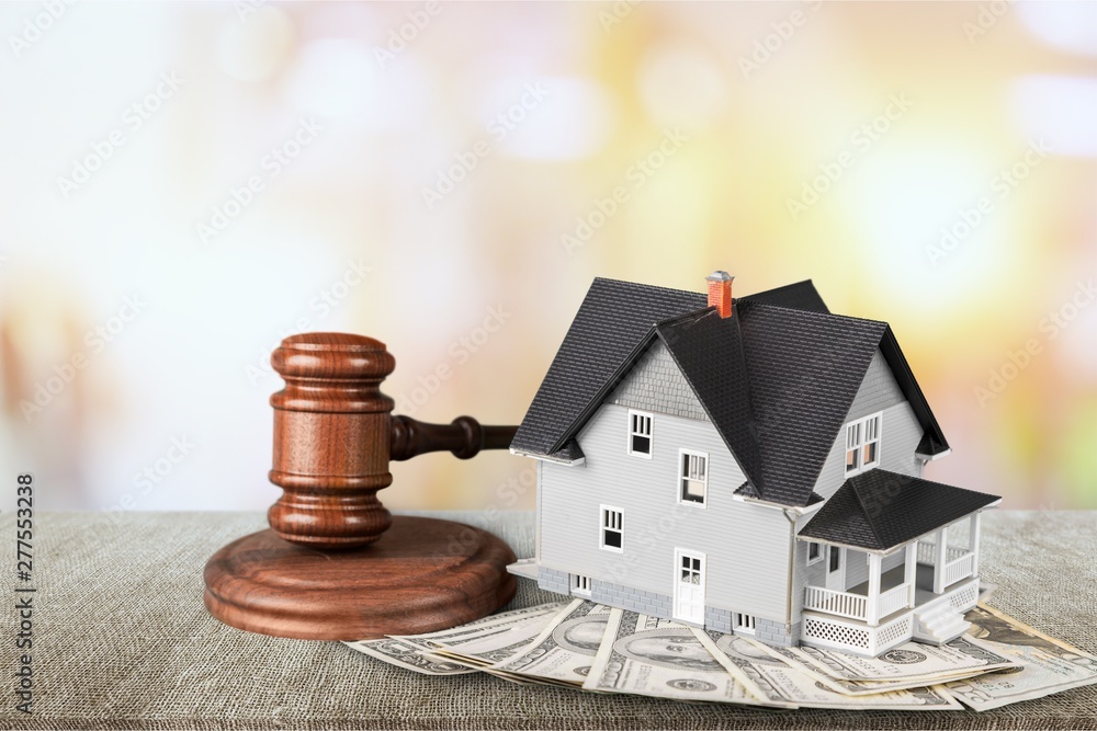 Wooden judge gavel and toy house on background Wooden judge gavel and toy house on background