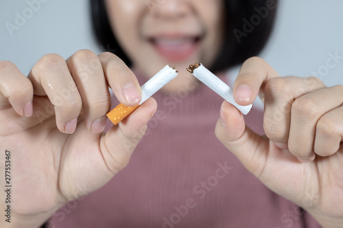 Young beautiful woman with broken cigarette. Stop smoking concept.
