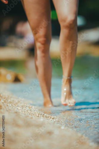 woman legs walking by seaside close up
