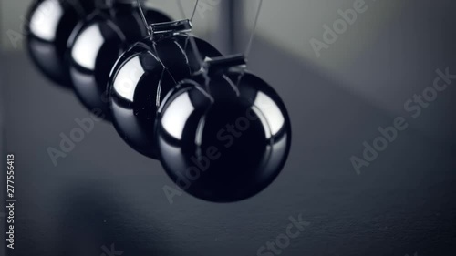 The chrome balls of a Newton’s Cradle colliding in slow motion