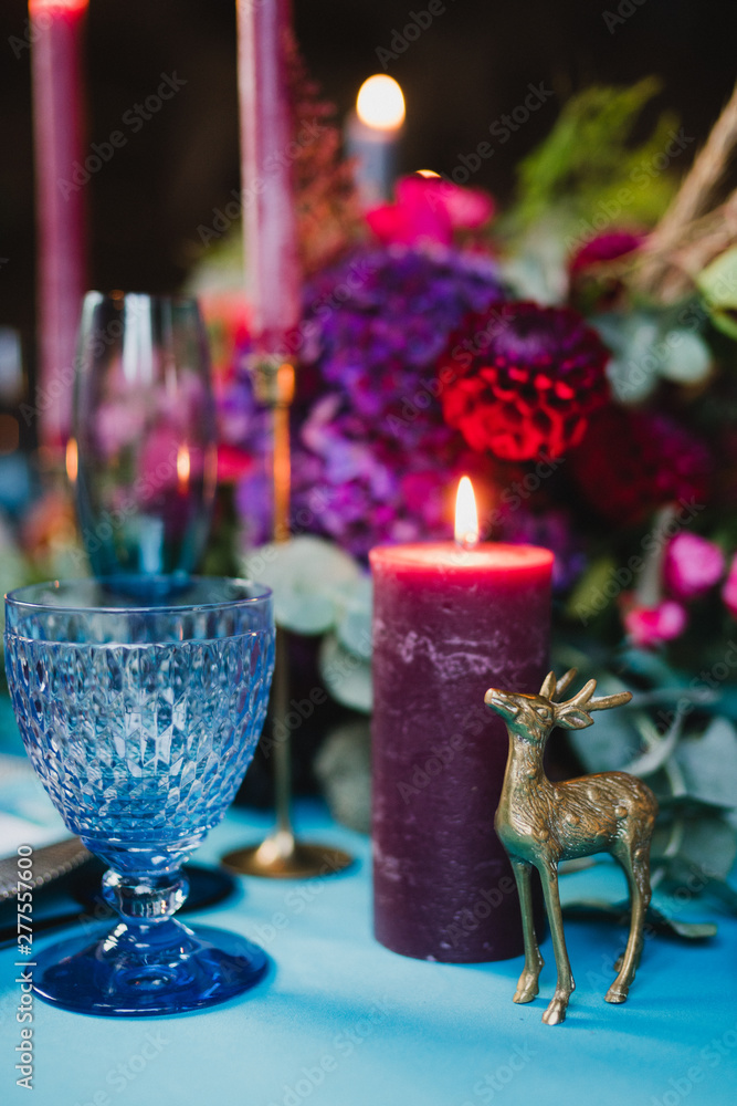 Coziness and style. Modern event design. Table setting at wedding reception. Floral compositions with beautiful flowers and greenery, candles, laying and plates on decorated table. Coziness and style. Modern event design. Table setting at wedding reception. Floral compositions with beautiful flowers and greenery, candles, laying and plates on decorated table.