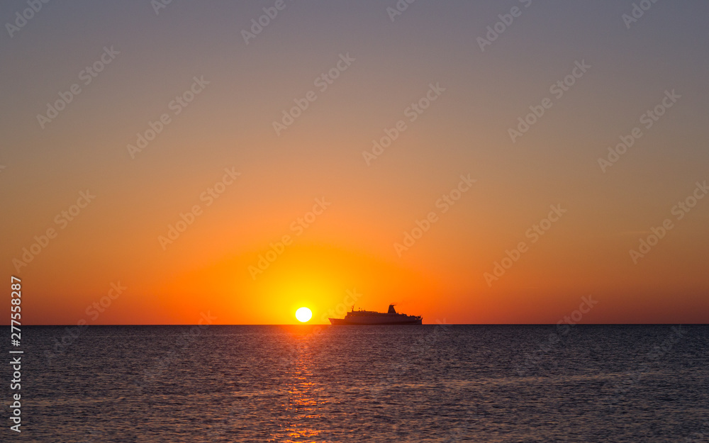 Silhouette of a tourist ship at sunset