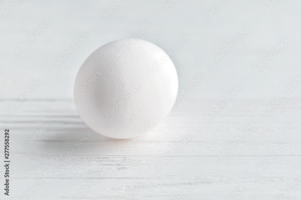 White chicken egg with selective focus on blurred textured gray background. Fresh organic fragility egg on neutral backdrop, soft focus. Ingredient for healthy diet breakfast. Easter symbol White chicken egg with selective focus on blurred textured gray background. Fresh organic fragility egg on neutral backdrop, soft focus. Ingredient for healthy diet breakfast. Easter symbol