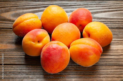 Apricots on wooden background. Pile of fresh juicy apricots piled on a wooden table.