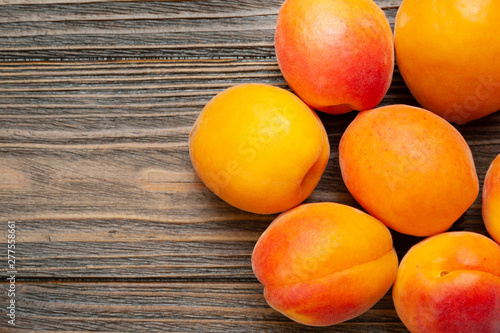Apricots on wooden background. Top view fresh juicy apricots piled on a wooden table.